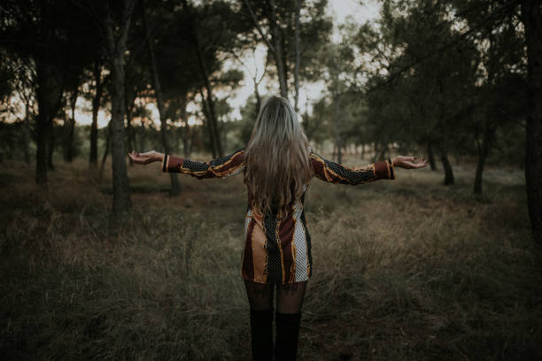 istock Young woman with arms raised at forest 1065548348
