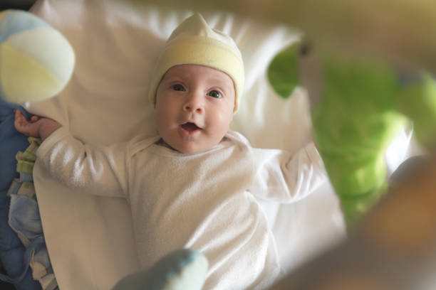 istock Playful baby lying in his crib smiling 1065548584