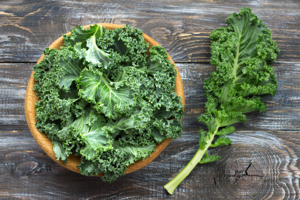 istock Fresh green curly kale leaves on a wooden table 1065548920