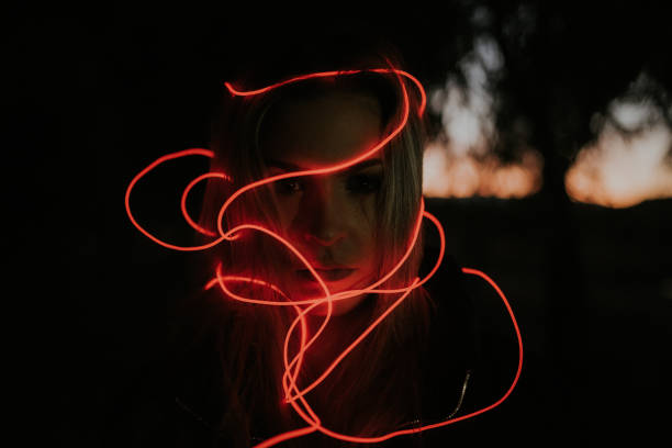 istock Young woman tangled in neon lights 1065548996