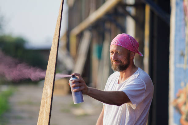 portrait of a young man spray paint artist stock photo