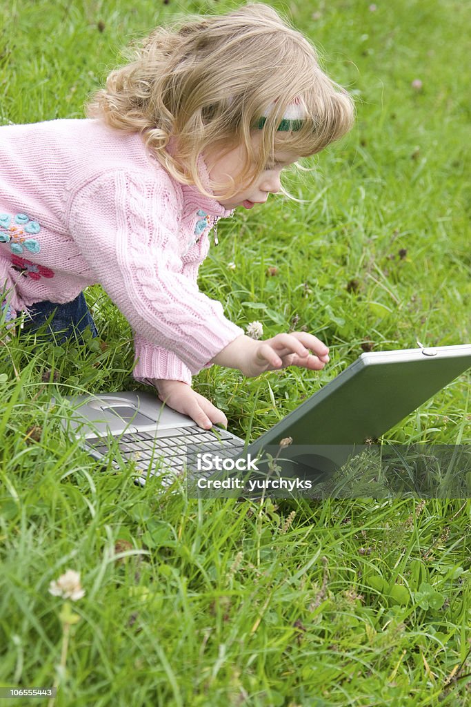 可愛らしいノートパソコンで遊ぶ少女 - インタ��ーネットのロイヤリティフリーストックフォト