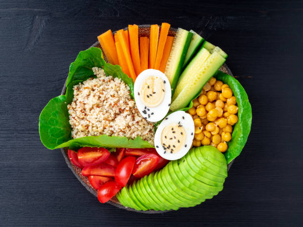 istock Vegetarian Buddha's bowl, a mix of vegetables. Avocado, quinoa, chickpeas, vegetables, eggs, top view 1065555976