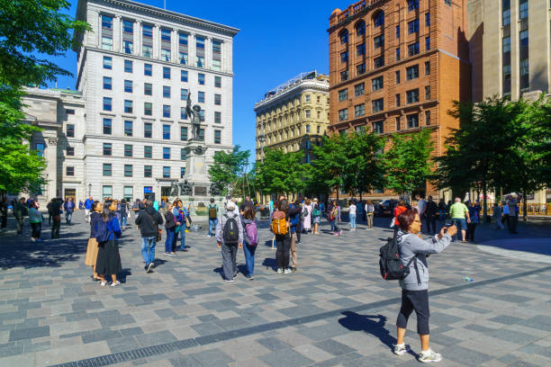Place dArmes square, in Montreal Montreal, Canada - September 08, 2018: Scene of Place dArmes square, with locals and visitors, in Montreal, Quebec, Canada place darmes montreal stock pictures, royalty-free photos & images