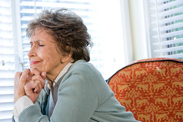 istock Elderly woman upset sitting alone by window 106557023
