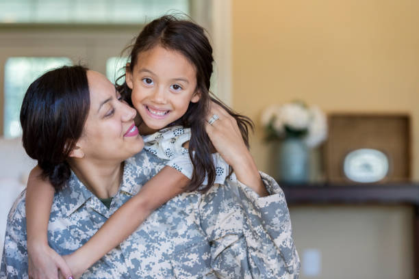 cheerful military mom is reunited with adorable daughter - military armed forces family veteran imagens e fotografias de stock