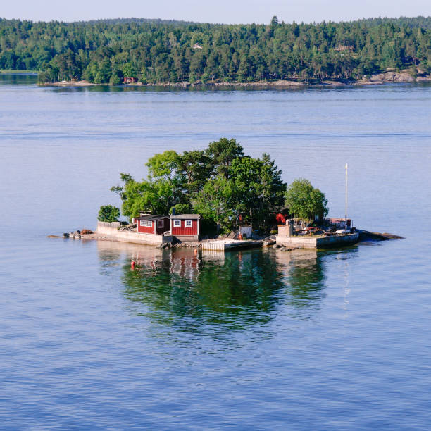 Small island in the Stockholm archipelago. Small island in the Stockholm archipelago. Red saunas and cross waves on square frame. swedish sauna stock pictures, royalty-free photos & images