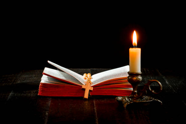 istock A rosary on the book, and a lit candle in a candlestick 1065586706