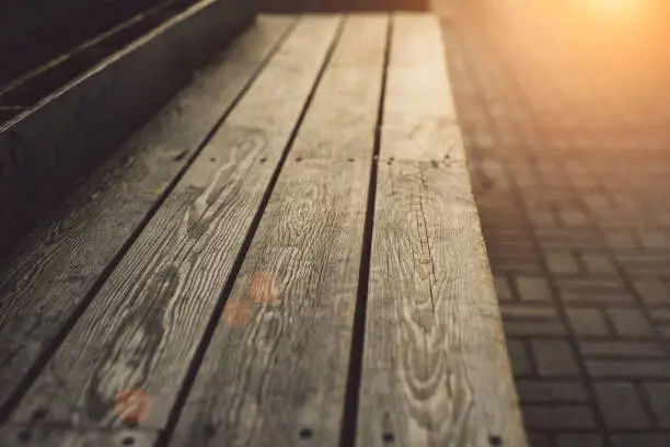 Modern wooden bench with deep texture close up at sunset warm light