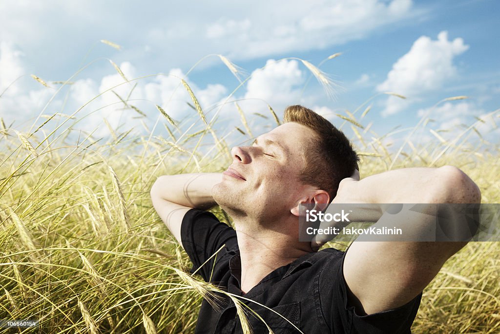 Молодой человек отдых на поле пшеницы - Стоковые фото Веселье роялти-фри