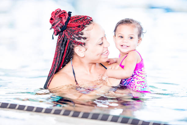 istock A black mother holding her daughter in a pool 1065608648