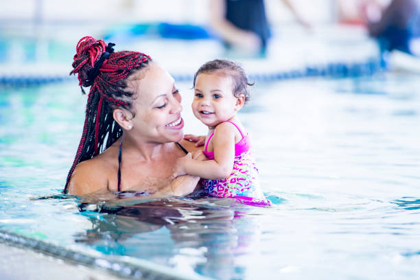 istock A black mother holds her daughter in a pool 1065608660
