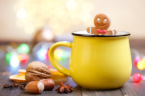 Gingerbread man and yellow mug with Christmas lights.