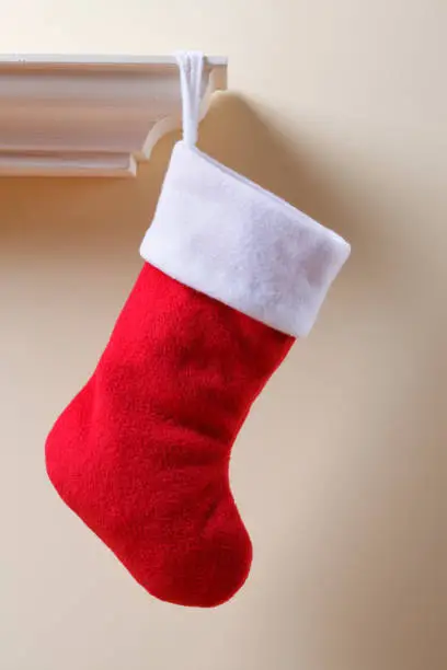 Traditional red Christmas stocking hanging on a mantel.