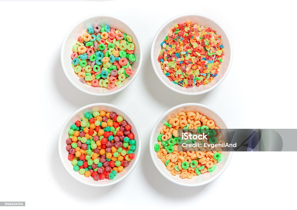 bowls of different colorful cereal on a white background. multicolored rings, balls and breakfast cereals. flat lay, top view Breakfast Cereal Stock Photo