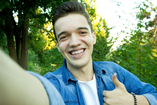 istock Young male smiling at the park is taking selfie. 1065626322