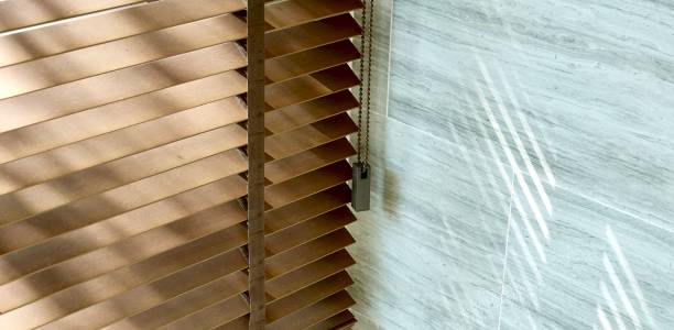 istock Evening sun light outside wooden window blinds, sunshine and shadow on window blind and Granite tile wall 1065629984