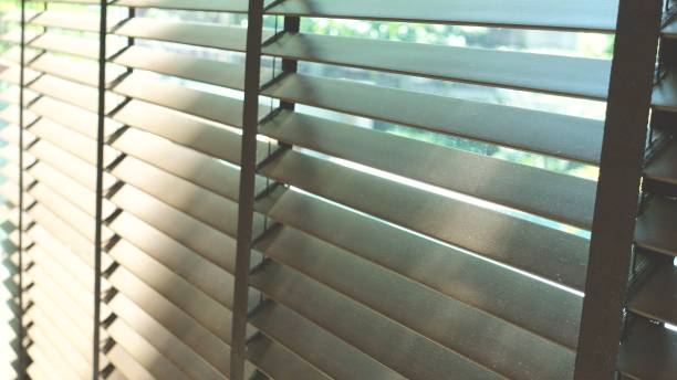 istock Evening sun light outside wooden window blinds, sunshine and shadow on window blind and Granite tile wall 1065630232