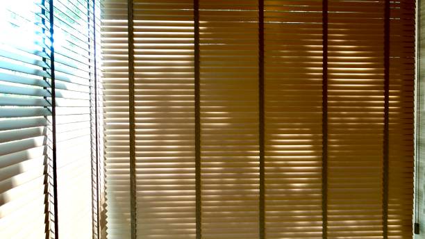 istock Evening sun light outside wooden window blinds, sunshine and shadow on window blind and Granite tile wall, decorative interior home 1065630568