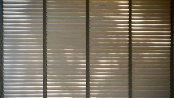 istock Evening sun light outside wooden window blinds, sunshine and shadow on window blind and Granite tile wall, decorative interior home 1065630676