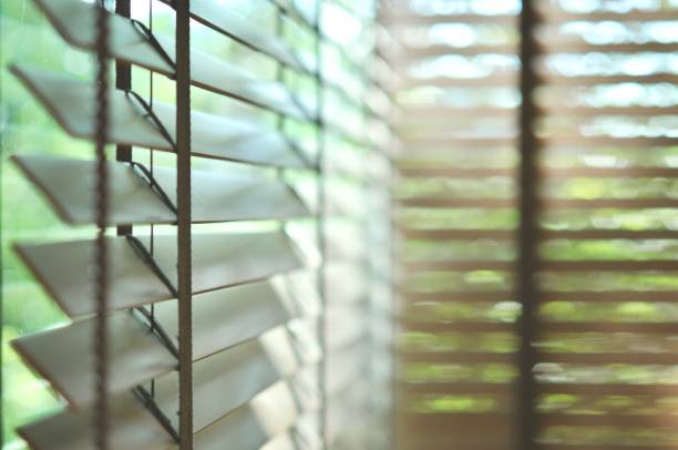 istock Evening sun light outside wooden window blinds, sunshine and shadow on window blind and Granite tile wall 1065631004