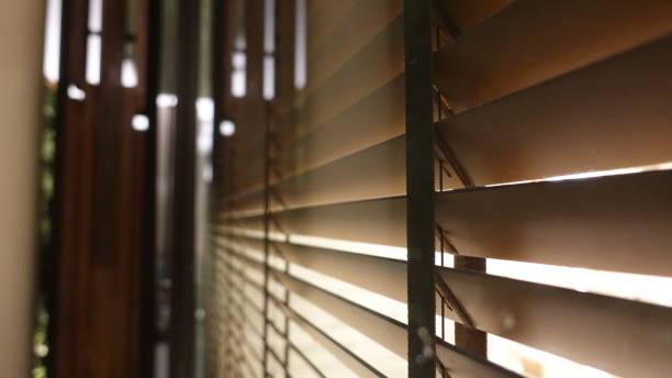 istock Evening sun light outside wooden window blinds, sunshine and shadow on window blind and Granite tile wall 1065634174