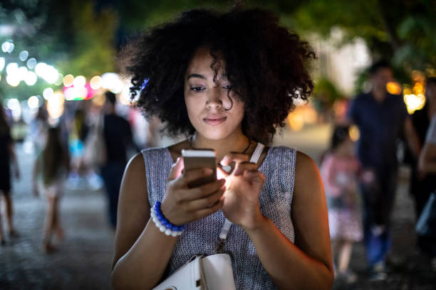 istock Woman walking and using smart phone on street 1065635816