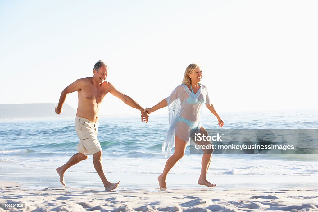 Altes Paar im Urlaub Laufen am Sandstrand - Lizenzfrei Alter Erwachsener Stock-Foto