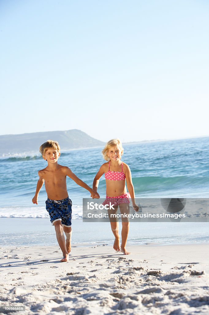 Niños corriendo en la playa de arena - Foto de stock de Bañador de natación libre de derechos