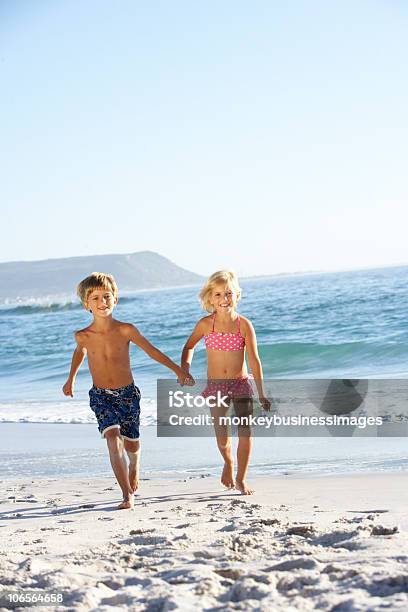 Niños Corriendo En La Playa De Arena Foto de stock y más banco de imágenes de Bañador de natación - Bañador de natación, Niños, 4-5 años