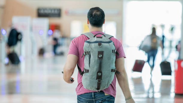 istock Hispanic traveler walking through airport lobby 1065677324