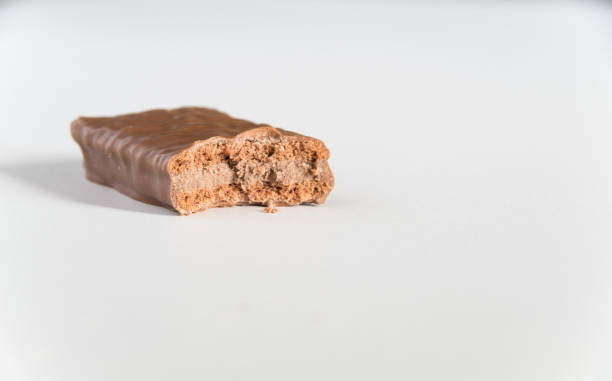 istock Chocolate biscuit with a bite taken on a white bench 1065687448