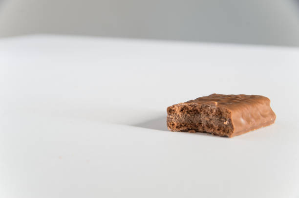 istock Chocolate biscuit with a bite taken on a white bench 1065687450