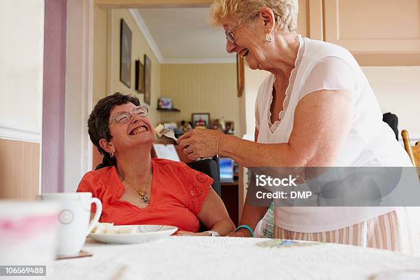 Photo libre de droit de Carer Femme Aidant À Mobilité Réduite Pour Manger Un Repas banque d'images et plus d'images libres de droit de Adulte