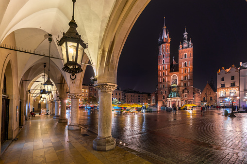 Krakow, Poland - October 21, 2018: Krakow  view showing arch view ,Old town square, Main market square, St. Mary's Church, buildings, restaurants, trees and people walking on the street  can be seen on the background at night