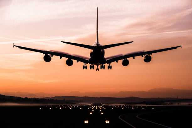 着陸飛行機 - landing sunset airplane flying ストックフォトと画像