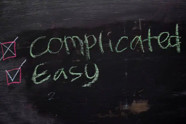 Complicated or Easy written with color chalk concept on the blackboard