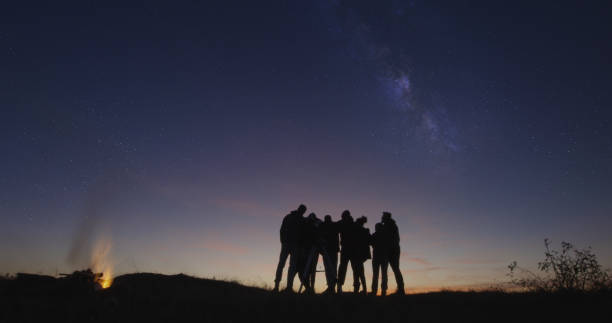 istock Friends with campfire looking on stars in the night sky 1065703018