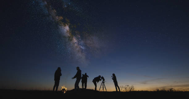 istock Friends with campfire looking on stars in the night sky 1065703034