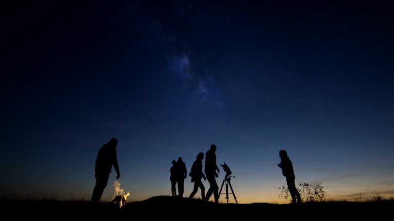 Adult friends stargazing together at night