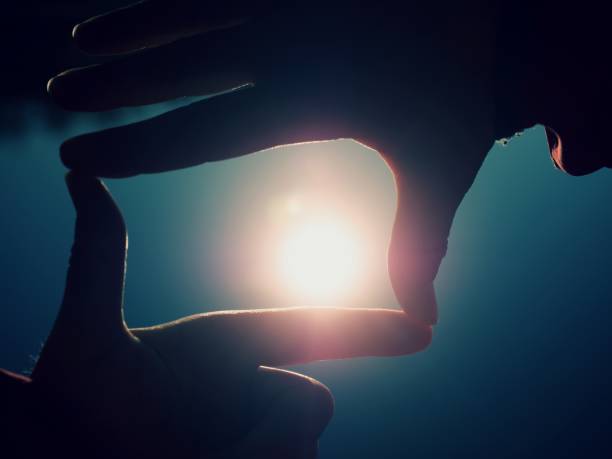 istock Hands catch sun at sunset time. Female fingers hold sun 1065703622