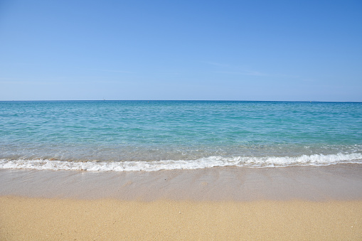 Summer sandy beach with a blue sea water