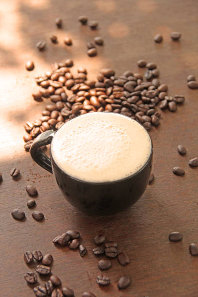 recién mañana café en una taza con granos de café - foto de stock