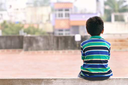 Indian Little Boy Sitting on The Wall