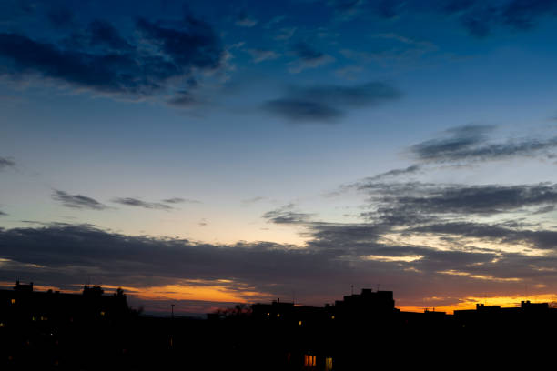 istock Sky with clouds at sunset over the evening city. Building Silhouettes 1065720122