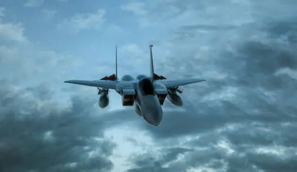 Photo of Armed military fighter jet in flight on the cloudly sky background - 3d render