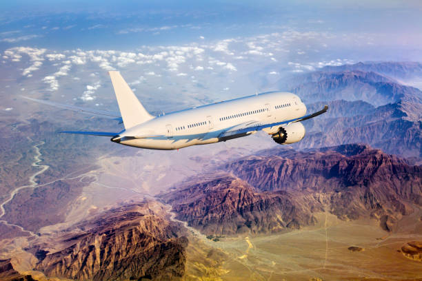 istock White passenger plane in flight. Aircraft rear view. 1065736604