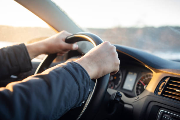 istock Driver's hand on steering wheel of car in cabin. 1065738032