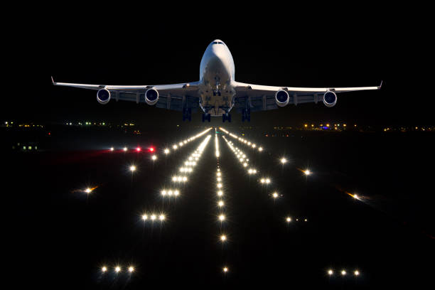 A passenger plane takes off from the night airport runway