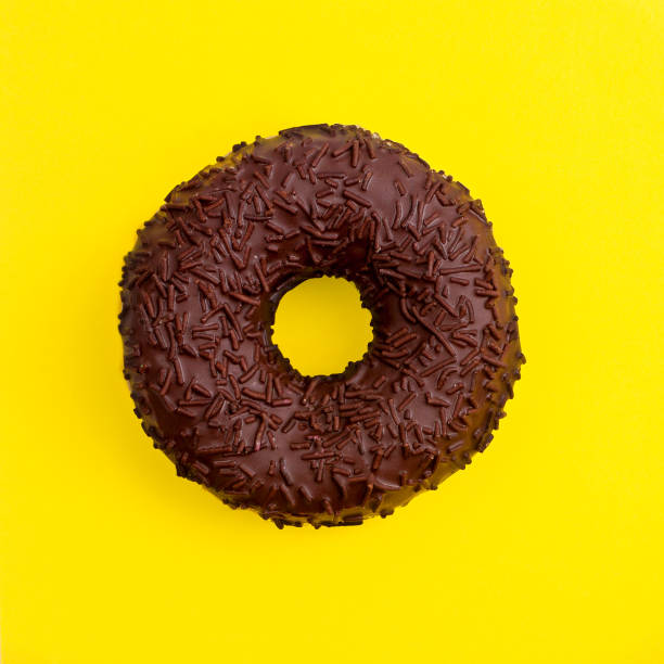istock Chocolate donut on a yellow background top view in a square 1065740144